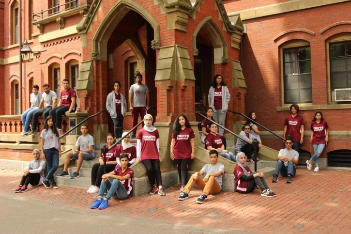 The students posing in front of Harvard University.
